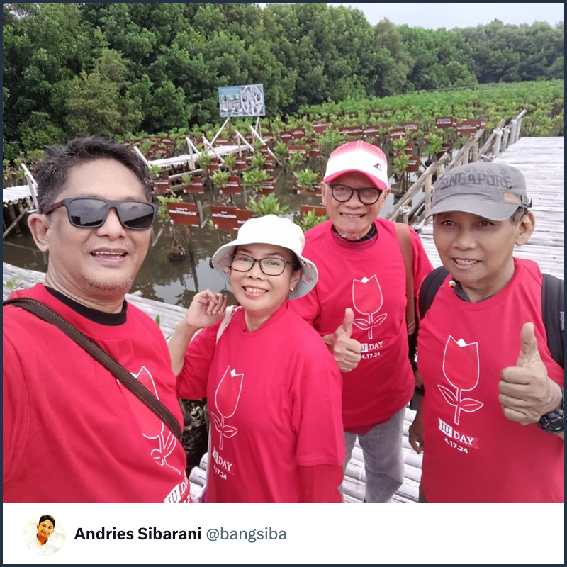 A group of four IU alumni in Jakarta, Indonesia, take a selfie in front of mangroves they planted in honor of IU Day.